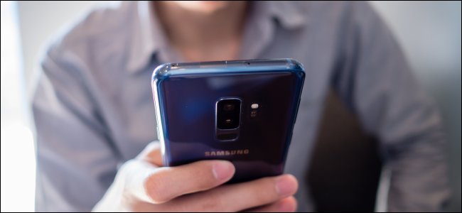 man holding blue Android phone
